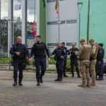 Guardas municipais e policiais militares em frente a comércio durante a Operação Fio Desencapado contra furto de fios de iluminação em São José.