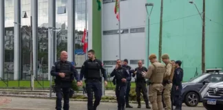 Guardas municipais e policiais militares em frente a comércio durante a Operação Fio Desencapado contra furto de fios de iluminação em São José.