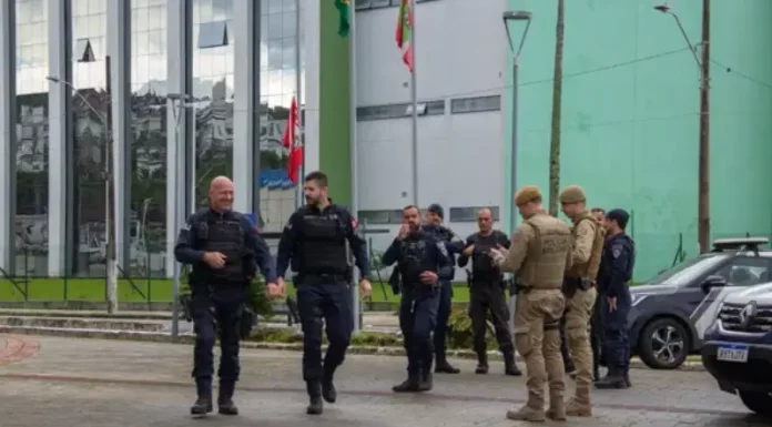 Guardas municipais e policiais militares em frente a comércio durante a Operação Fio Desencapado contra furto de fios de iluminação em São José.