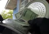 Mãos de policial federal segurando documentos apreendidos durante operação que investiga fraude bancária.