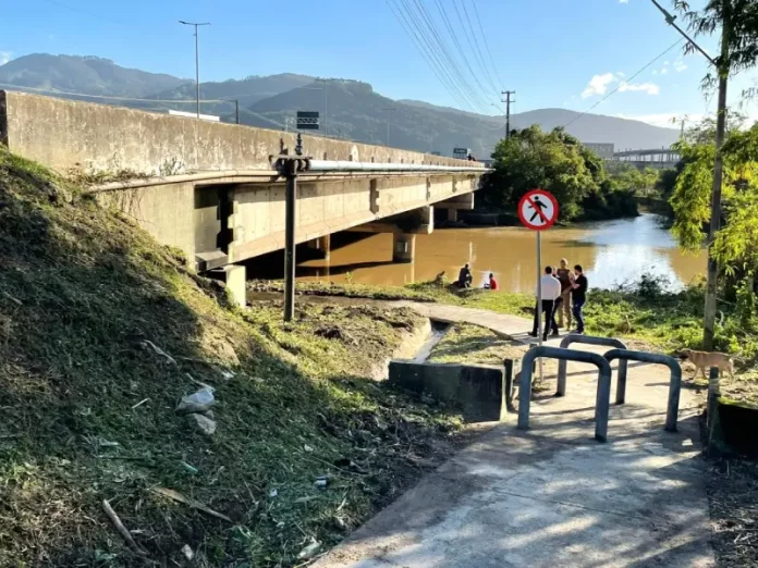Autoridades visitam passagem de pedestres sob o Rio Biguaçu, local que receberá câmeras de reconhecimento facial para aumentar a segurança.