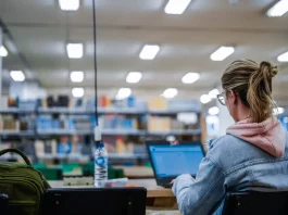 Estudante do Universidade Gratuita usando notebook em sala de aula