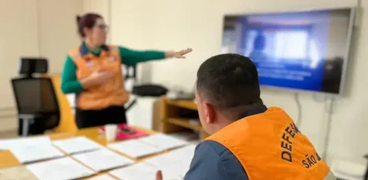 Agentes da Defesa Civil de São José analisam documentos sobre áreas de risco que receberão obras do Novo PAC.