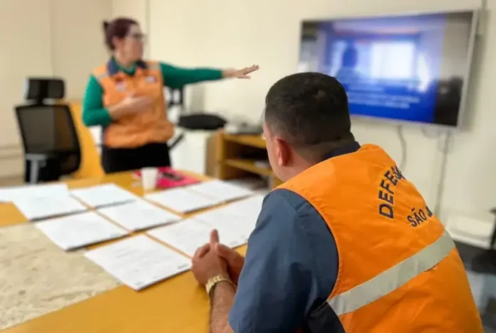 Agentes da Defesa Civil de São José analisam documentos sobre áreas de risco que receberão obras do Novo PAC.
