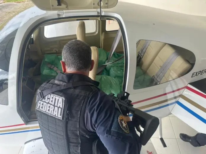 Agente da Receita Federal vistoria aeronave durante operação que apreendeu 571 iPhones em Porto Belo.