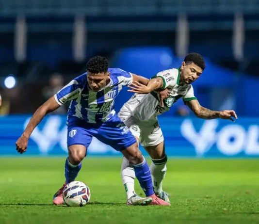 Jogador do Avaí e do Coritiba disputam a bola em campo, representando a intensidade e a rivalidade do duelo pelo Brasileirão.