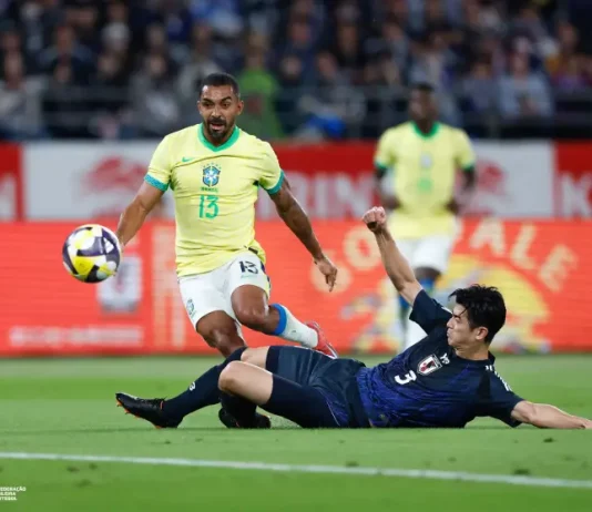 O futebol que encanta e decepciona: o retrato de uma paixão nacional Jogador da seleção brasileira tenta avançar com a bola enquanto é desarmado por um defensor da seleção japonesa durante uma partida de futebol. A imagem ilustra o confronto entre Brasil e Japão, usada para representar o tema do desempenho da seleção brasileira.