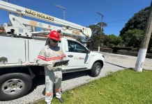 Funcionário da Celesc utilizando tablet em frente a veículo de atendimento emergencial, ilustrando o uso da internet Starlink para agilizar operações em campo.