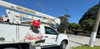 Funcionário da Celesc utilizando tablet em frente a veículo de atendimento emergencial, ilustrando o uso da internet Starlink para agilizar operações em campo.