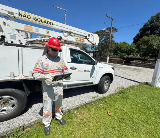 Funcionário da Celesc utilizando tablet em frente a veículo de atendimento emergencial, ilustrando o uso da internet Starlink para agilizar operações em campo.