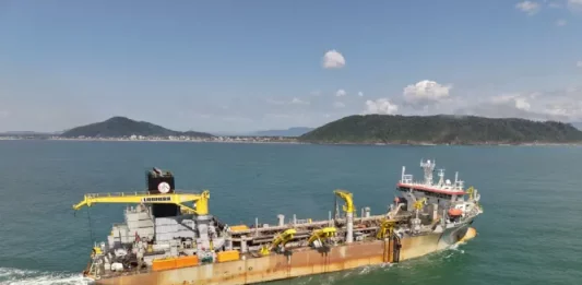 Draga Galileu Galilei em operação realizando a dragagem na Baía da Babitonga, processo que aprofunda o canal de acesso aos portos e gera areia para engordar a praia de Itapoá.