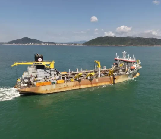 Draga Galileu Galilei em operação realizando a dragagem na Baía da Babitonga, processo que aprofunda o canal de acesso aos portos e gera areia para engordar a praia de Itapoá.