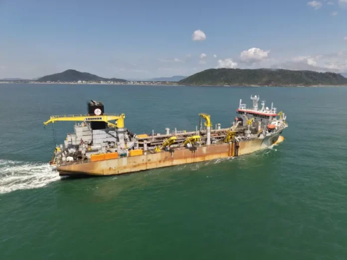 Draga Galileu Galilei em operação realizando a dragagem na Baía da Babitonga, processo que aprofunda o canal de acesso aos portos e gera areia para engordar a praia de Itapoá.