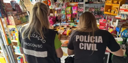 Agentes da Polícia Civil e do PROCON-SC realizam fiscalização em estabelecimentos comerciais na Grande Florianópolis em busca de bebidas falsificadas. A imagem ilustra a operação conjunta de combate à venda ilegal de produtos.