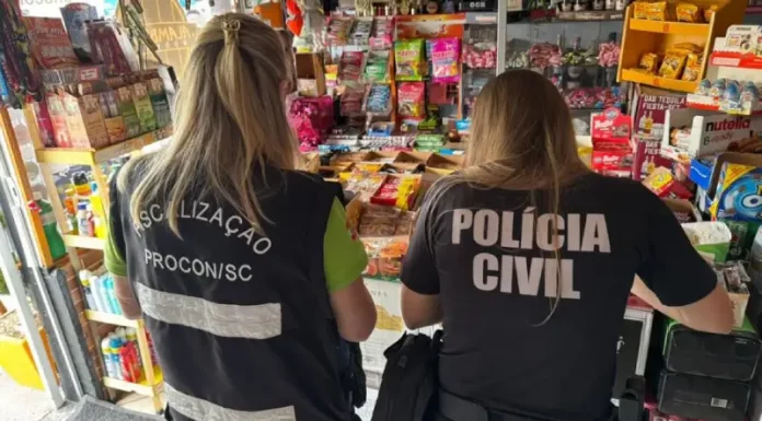 Agentes da Polícia Civil e do PROCON-SC realizam fiscalização em estabelecimentos comerciais na Grande Florianópolis em busca de bebidas falsificadas. A imagem ilustra a operação conjunta de combate à venda ilegal de produtos.