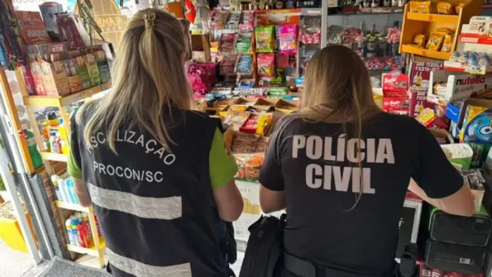 Agentes da Polícia Civil e do PROCON-SC realizam fiscalização em estabelecimentos comerciais na Grande Florianópolis em busca de bebidas falsificadas. A imagem ilustra a operação conjunta de combate à venda ilegal de produtos.