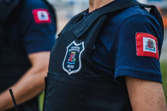 Foto mostra o tronco de um agente da Guarda Municipal fardado, destacando o uniforme oficial da corporação.