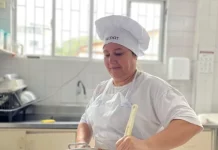 Maise Ferreira de Jesus, cozinheira da rede municipal de Florianópolis, prepara uma refeição em panela sobre o fogão, ilustrando seu trabalho na alimentação escolar