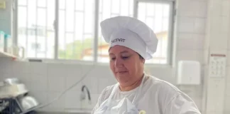 Maise Ferreira de Jesus, cozinheira da rede municipal de Florianópolis, prepara uma refeição em panela sobre o fogão, ilustrando seu trabalho na alimentação escolar