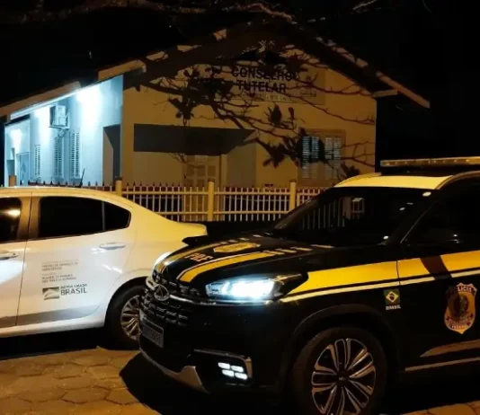 Carro da PRF ao lado do veículo do Conselho Tutelar, ilustrando o resgate e o acolhimento da criança encontrada sozinha na BR-101.