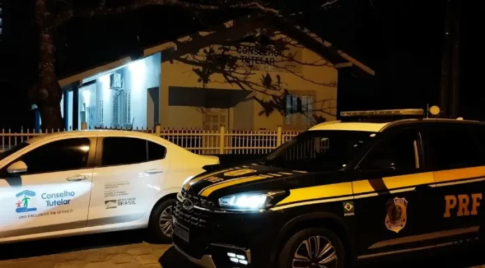 Carro da PRF ao lado do veículo do Conselho Tutelar, ilustrando o resgate e o acolhimento da criança encontrada sozinha na BR-101.