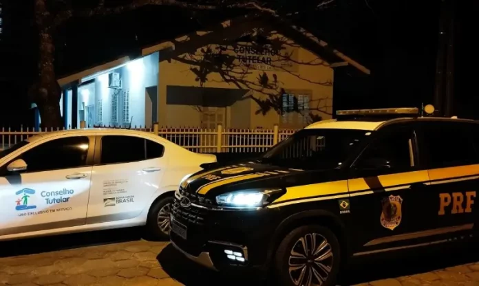 Carro da PRF ao lado do veículo do Conselho Tutelar, ilustrando o resgate e o acolhimento da criança encontrada sozinha na BR-101.
