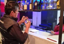 Diretor do Procon de São José analisa rótulo de produto durante fiscalização da Operação Primeiro Gole, em busca de bebidas adulteradas.