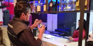 Diretor do Procon de São José analisa rótulo de produto durante fiscalização da Operação Primeiro Gole, em busca de bebidas adulteradas.