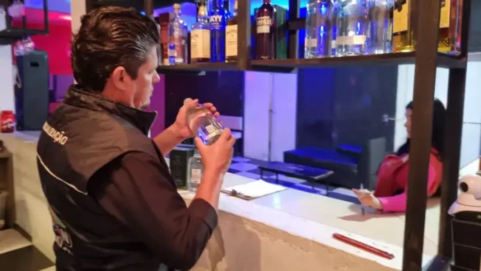Diretor do Procon de São José analisa rótulo de produto durante fiscalização da Operação Primeiro Gole, em busca de bebidas adulteradas.