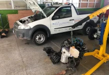 Fiorino branca com capô aberto no laboratório do Projeto Converte, mostrando o processo de conversão de veículo a combustão para elétrico.