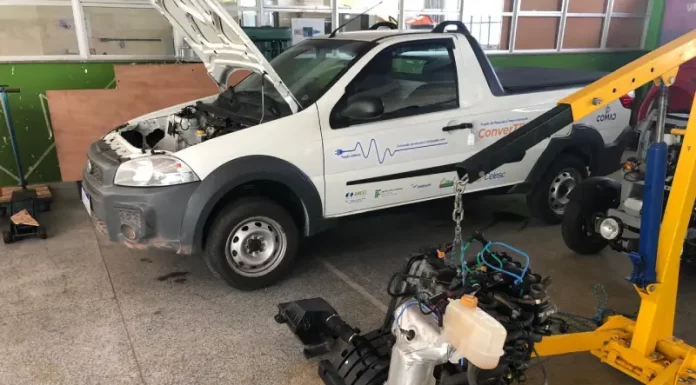 Projeto Converte da Celesc e IFSC transforma carros a combustão em elétricos e impulsiona a mobilidade Fiorino branca com capô aberto no laboratório do Projeto Converte, mostrando o processo de conversão de veículo a combustão para elétrico.