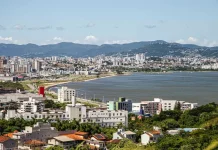Vista aérea de São José mostrando o mar e a Beira-Mar, com prédios da cidade que ilustram o perfil urbano e populacional do município.