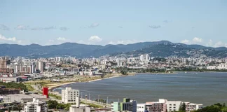 Vista aérea de São José mostrando o mar e a Beira-Mar, com prédios da cidade que ilustram o perfil urbano e populacional do município.