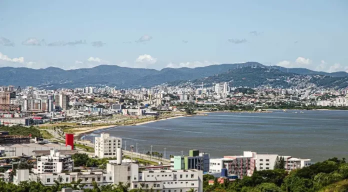 Perfil da população de São José: IBGE mostra cidade urbana e alfabetizada Vista aérea de São José mostrando o mar e a Beira-Mar, com prédios da cidade que ilustram o perfil urbano e populacional do município.
