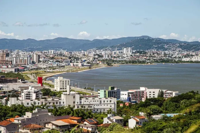 Vista aérea de São José mostrando o mar e a Beira-Mar, com prédios da cidade que ilustram o perfil urbano e populacional do município.