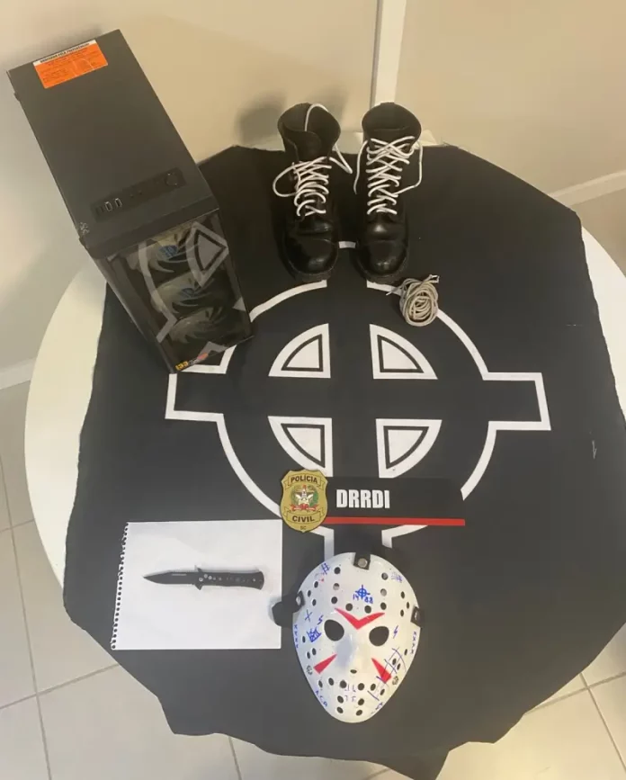 apologia ao nazismo Imagem mostra objetos apreendidos pela Polícia Civil durante o cumprimento de mandado, incluindo símbolos nazistas e equipamentos eletrônicos usados para divulgação de conteúdo racista.