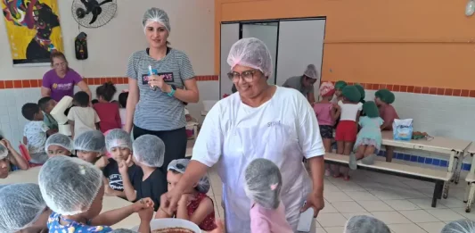 O sonho de Stela: ser cozinheira de um grande público Cozinheira Stela na cozinha do NEIM Mateus de Barros, auxiliando crianças no preparo da massa de bolo, em atividade educativa e prática de alimentação saudável.