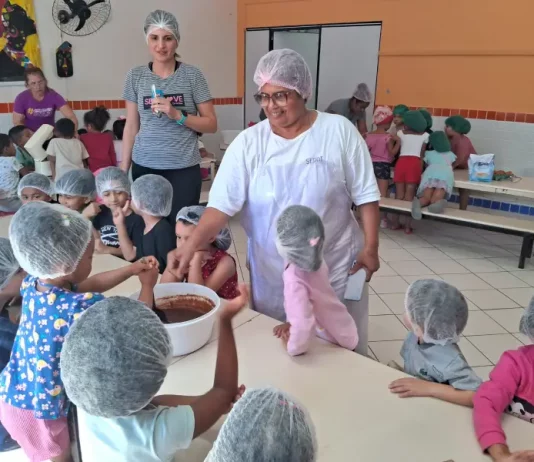 O sonho de Stela: ser cozinheira de um grande público Cozinheira Stela na cozinha do NEIM Mateus de Barros, auxiliando crianças no preparo da massa de bolo, em atividade educativa e prática de alimentação saudável.