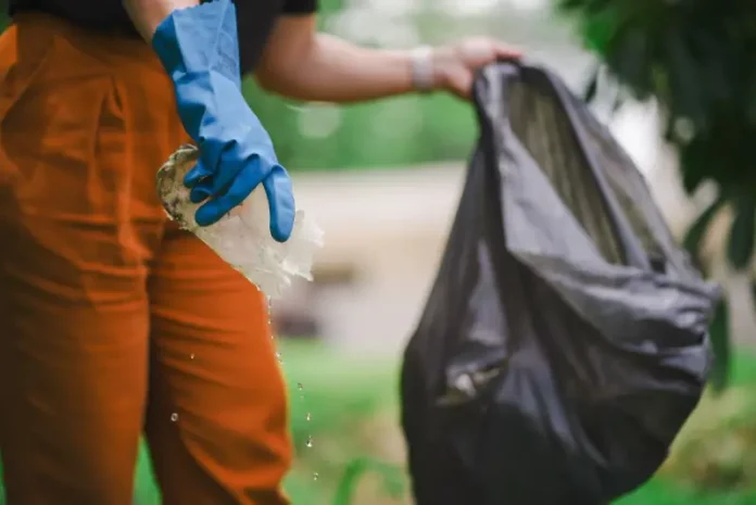 dengue-2 Homem recolhendo um pedaço de plástico com água parada para eliminar possíveis criadouros do mosquito Aedes aegypti e focos de dengue.