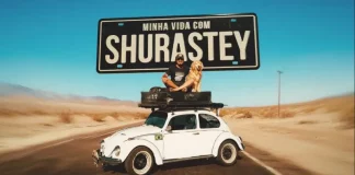 Cena promocional do filme “Minha Vida com Shurastey”, mostrando um homem e seu cachorro sobre um fusca branco em uma estrada desértica, sob uma placa com o título do longa. A imagem é usada para divulgar a produção inspirada na história real de Jesse Kozechen e seu cão Shurastey.