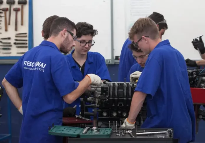 Jovens aprendizes em ambiente de trabalho, ilustrando oportunidades de educação e emprego no estado.