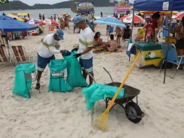 Comcap reabre chamada para prova prática do concurso de gari temporário Garis coletando lixo na praia durante o verão, ilustrando a contratação temporária da Comcap.