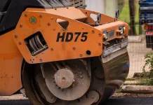 Rolo compressor realizando pavimentação de rua em Biguaçu, representando obras de infraestrutura da cidade.