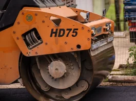 Biguaçu garante R$ 20 milhões para pavimentação na cidade Rolo compressor realizando pavimentação de rua em Biguaçu, representando obras de infraestrutura da cidade.