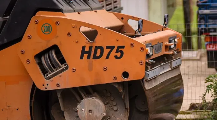 Biguaçu garante R$ 20 milhões para pavimentação na cidade Rolo compressor realizando pavimentação de rua em Biguaçu, representando obras de infraestrutura da cidade.