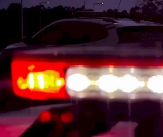 Giroflex de viatura da Polícia Militar ligado à noite, simbolizando a atuação da polícia no atendimento ao caso de golpe telefônico envolvendo idosos.