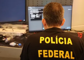 Agente da Polícia Federal analisa dados em computador durante operação que investiga fraudes bancárias digitais.