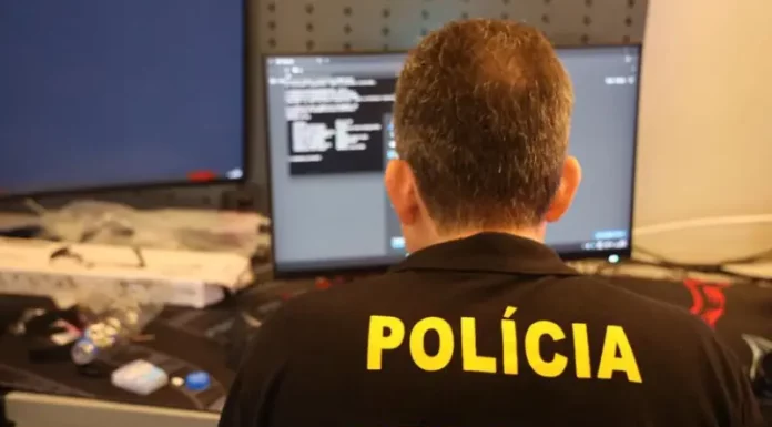 Agente da Polícia Federal analisa dados em computador durante operação que investiga fraudes bancárias digitais.