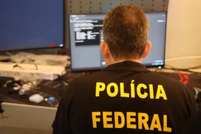 polícia federal Agente da Polícia Federal analisa dados em computador durante operação que investiga fraudes bancárias digitais.