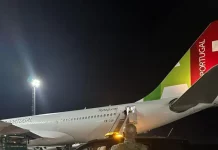 Agente da Polícia Federal acompanha, na pista do Aeroporto Internacional de Florianópolis, o embarque de cidadão finlandês em voo internacional durante operação de expulsão do país.